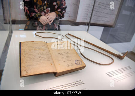 Stuttgart, Deutschland. 10 Dez, 2018. Ein neues Testament und eine Peitsche aus dem Nachlass von Hendrik Witbooi sind in einer Vitrine im Linden Museum für Völkerkunde. Das Land Baden-Württemberg will die Exponate als gestohlener Kulturgüter zu Namibia im Februar zurück. Beide Objekte werden wieder im Lindenmuseum ausgestellt werden, bis sie zurückgegeben werden. Credit: Marijan Murat/dpa/Alamy leben Nachrichten Stockfoto