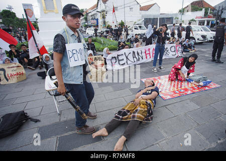 Yogyakarta, Indonesien. 10. Dezember, 2018. Studenten aus der zivilen Bildung und Recht von Yogyakarta State University, theatralische Performance zum Internationalen Tag der Menschenrechte am Tugu Jogja gedenken. Sie wollen die Regierung Menschenrechtsverletzungen in Indonesien zu untersuchen. Galih Yoga Wicaksono/Alamy leben Nachrichten Stockfoto