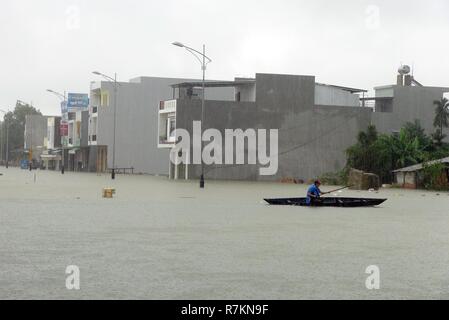 Hanoi, Vietnam. 10 Dez, 2018. Ein anwohner Zeilen ein Boot auf eine überflutete Straße in Phong Dien Bezirk, Provinz Thua Thien Hue, Vietnam, 10.12.2018. Heavy Rain in den letzten drei Tagen führte zu schweren Überschwemmungen in Vietnam Region. Credit: VNA/Xinhua/Alamy leben Nachrichten Stockfoto