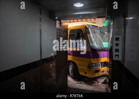 Hongkong, China. 10. Dezember 2018. Eine leere Schulbus an der Unfallstelle gesehen. Polizisten durchführen Untersuchung nach einem unbemannten leere Schulbus in einem vorwiegend Wohngegend abgestürzt. Die Polizei vermutet, dass der Fahrer vergessen die Handbremse nach dem Parken mit dem Bus auf einer Steigung, die zu dem tödlichen Unfall, töten 4 und verletzte 10 weitere. Credit: SOPA Images Limited/Alamy leben Nachrichten Stockfoto