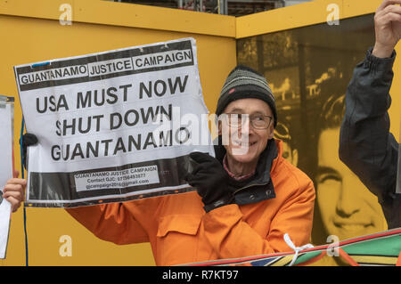 London, Großbritannien. 10. Dezember 2018. Eine Demonstrantin hält ein Plakat an der abschließenden's Hütte Guantanamo!" monatliche Protest von 2018 bei der US-Botschaft auf der 70. Jahrestag der Allgemeinen Erklärung der Menschenrechte (AEMR). Dies erklärte: "Niemand darf gefoltert oder grausamer, unmenschlicher oder erniedrigender Behandlung oder Strafe' und 'kann nicht willkürlich festgenommen, in Haft gehalten oder des Landes verwiesen werden." Guantánamo hat noch 40 Gefangenen, die gefoltert wurden und in unbefristete Inhaftierung ohne Gerichtsverfahren für fast 17 Jahre gehalten. Credit: Peter Marschall/Alamy leben Nachrichten Stockfoto