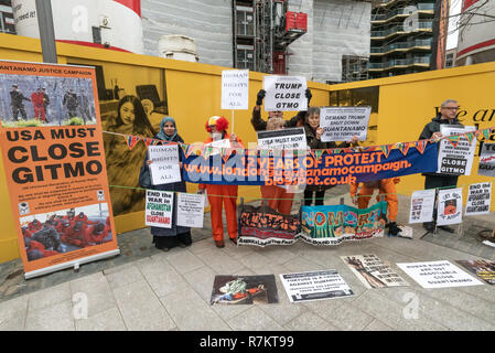 London, Großbritannien. 10. Dezember 2018. Die Demonstranten mit Transparenten und Plakaten gegenüber der US-Botschaft am abschließenden's Hütte Guantanamo!" monatliche Protest von 2018 bei der US-Botschaft auf der 70. Jahrestag der Allgemeinen Erklärung der Menschenrechte (AEMR). Dies erklärte: "Niemand darf gefoltert oder grausamer, unmenschlicher oder erniedrigender Behandlung oder Strafe' und 'kann nicht willkürlich festgenommen, in Haft gehalten oder des Landes verwiesen werden." Guantánamo hat noch 40 Gefangenen, die gefoltert wurden und in unbefristete Inhaftierung ohne Gerichtsverfahren für fast 17 Jahre gehalten. Credit: Peter Marschall/Alamy leben Nachrichten Stockfoto