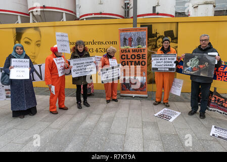 London, Großbritannien. 10. Dezember 2018. Die Demonstranten mit Transparenten und Plakaten gegenüber der US-Botschaft am abschließenden's Hütte Guantanamo!" monatliche Protest von 2018 bei der US-Botschaft auf der 70. Jahrestag der Allgemeinen Erklärung der Menschenrechte (AEMR). Dies erklärte: "Niemand darf gefoltert oder grausamer, unmenschlicher oder erniedrigender Behandlung oder Strafe' und 'kann nicht willkürlich festgenommen, in Haft gehalten oder des Landes verwiesen werden." Guantánamo hat noch 40 Gefangenen, die gefoltert wurden und in unbefristete Inhaftierung ohne Gerichtsverfahren für fast 17 Jahre gehalten. Credit: Peter Marschall/Alamy leben Nachrichten Stockfoto