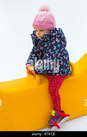 Winchester, Hampshire, UK. 10. Dezember 2018. Junges Mädchen sitzt auf Kinder skating Beihilfe auf die Freiluft Eislaufbahn auf Winchester Cathedral Eisbahn. Credit: Carolyn Jenkins/Alamy leben Nachrichten Stockfoto