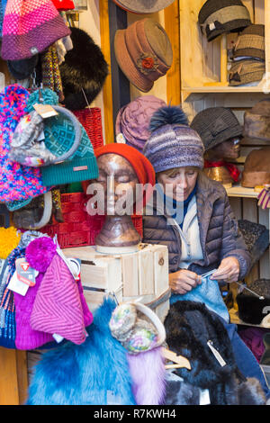 Winchester, Hampshire, UK. 10. Dez 2018. Menschenmassen strömen in Winchester Weihnachtsmarkt, während die Sonne scheint. Abschaltdruck Inhaber verkauf Hüte sat stricken. Credit: Carolyn Jenkins/Alamy leben Nachrichten Stockfoto