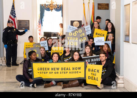 Washington, DC, USA. 10 Dez, 2018. Die demonstranten gesehen Plakate während der Sunrise Bewegung Protest im Büro der US-Vertreter Nancy Pelosi (D-CA) zu befürworten, dass die Demokraten unterstützt die Green New Deal, bei den US-Kapitol in Washington, DC. Quelle: Michael Brochstein/SOPA Images/ZUMA Draht/Alamy leben Nachrichten Stockfoto