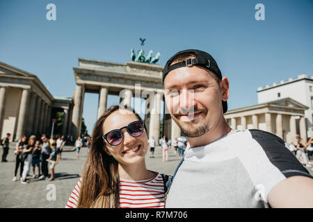 Junge schöne Paar machen selfie vor dem Hintergrund des Brandenburger Tor in Berlin in Deutschland. Stockfoto