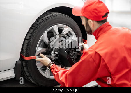 Stattliche Automechaniker in Rot einheitliche Festsetzung Festplatte für Spur am Auto Service Stockfoto