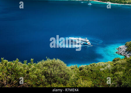 Luxus weißen Yacht segeln Boot ankern in einer ruhigen Bucht im tiefen blauen Wasser Wasser, in der Nähe der malerischen Ufer des griechischen Inseln Stockfoto