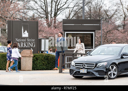 Washington DC, USA - April 1, 2018: die Menschen zu Fuß von der Basilika von Nationalheiligtum der Unbefleckten Empfängnis Katholische Kirche Parkplatz sig Stockfoto