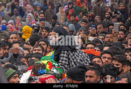 Hajin, Kaschmir. 10. Dezember, 2018. Schwester eines 14 Jahre alten militanten Mudasir Rashid neben den Toten während der Trauerfeier in der Hajin im Norden von Kaschmir liegt rund 35 Kilometer von Srinagar im Sommer, die Hauptstadt der indischen Teil Kaschmirs am 10. Dezember 2018 geregelt. Vierzehn Jahr alt war unter den drei Kämpfer in 18-Stunden langen Waffe getötet - Schlacht im Mujigund Bereich auf der Srinagar Stadtrand am 09. Dezember 2018. Credit: Faisal Khan/Pacific Press/Alamy leben Nachrichten Stockfoto