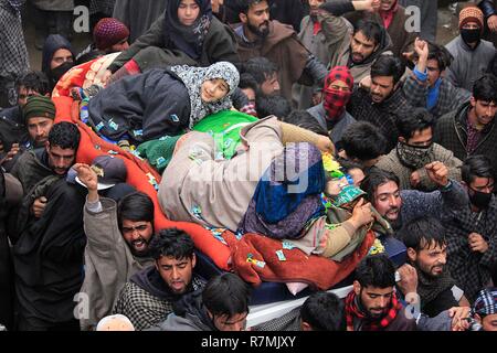 Hajin, Kaschmir. 10. Dezember, 2018. Mutter und Schwester, als ein Jugendlicher militante Sakib Bilal trauern Neben den Toten während der Trauerfeier in der Hajin im Norden von Kaschmir rund 35 Kilometer von Srinagar im Sommer, die Hauptstadt der indischen Teil Kaschmirs am 10. Dezember 2018 geregelt. Vierzehn Jahr alt war unter den drei Kämpfer in 18-Stunden langen Waffe getötet - Schlacht im Mujigund Bereich auf der Srinagar Stadtrand am 09. Dezember 2018. Credit: Faisal Khan/Pacific Press/Alamy leben Nachrichten Stockfoto