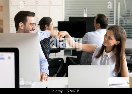 Freundlich lächelnden Kollegen Faust stoßen am Arbeitsplatz Stockfoto