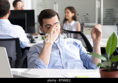 Müde Geschäftsmann massieren Nasensteg lehnte sich zurück in den Stuhl Stockfoto