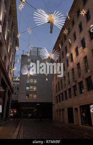 Engel Weihnachtsbeleuchtung aufhängen über Geschäfte im Carlton Street, St James Regent Street, London, 2018 Stockfoto