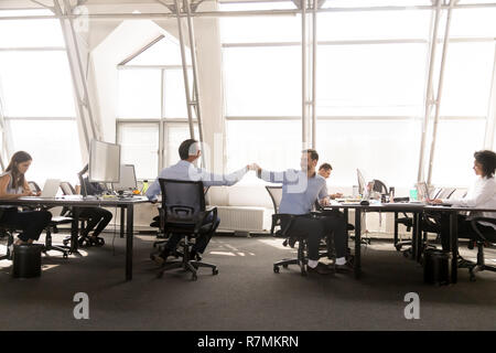 Freundlich männlichen Kollegen Faust stoßen am Arbeitsplatz Stockfoto