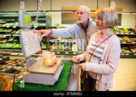 Senior Paar wiegen Frucht am SB-Waage während des Einkaufs in den Obst und Gemüse Abteilung eines Supermarkts. Stockfoto