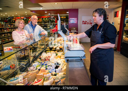 Shop Assistant ein älterer Paare an der Käsetheke, Einkaufen in einem Supermarkt, Deutschland Stockfoto