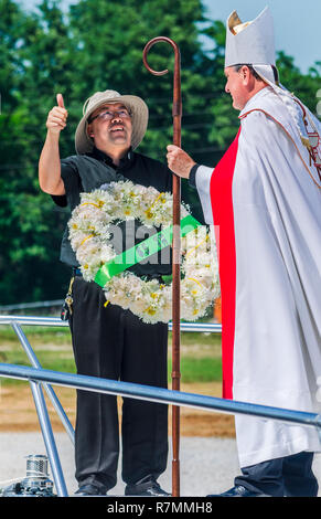 Pastor Nguyen Bieu hält eine feierliche Kranzniederlegung, wie er im Gespräch mit Erzbischof Thomas J. Rodi an den Segen der Flotte im Bayou La Batre, Alabama. Stockfoto