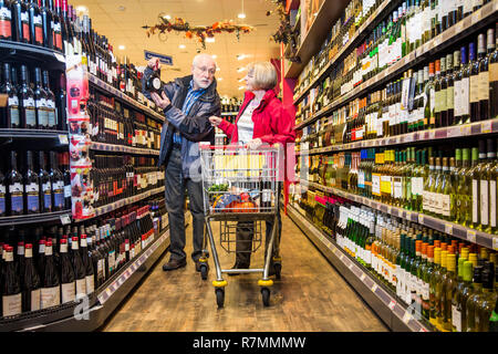 Senior Paar Einkaufen in der Weinabteilung im Supermarkt, Deutschland Stockfoto