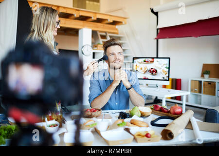 Portrait von Make-up Artist Anwendung zu beenden, schöner TV-Show Host im Kochstudio, kopieren Raum Stockfoto