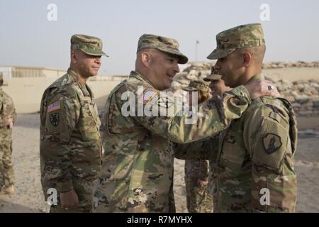 Brig. Gen. Alberto Rosende, Kommandierender General der 1. Mission unterstützt den Befehl, eine Armee finden Einheit aus Fort Buchanan, Puerto Rico, klatscht der Garita Patch auf ein Soldat während einer Zeremonie für das Patchen der 246th Quartermaster Firma (leichenhalle Angelegenheiten) im Camp Arifjan, Kuwait, am März 20, 2017. Stockfoto