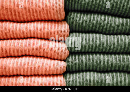 Zwei Stapel von warmen Braun- und Beigetönen gestrickte Pullover in einer Reihe. Herbst- und Winterkleidung. Stockfoto