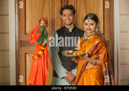 Happy maharashtrian Paar in traditioneller Kleidung feiern Gudi padwa Festival mit einem pooja Platte und posieren. Stockfoto