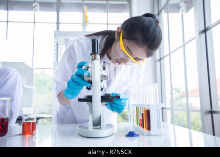 Medizinische Forschung und Wissenschaftler arbeiten mit Mikroskop und eine Tablette und Reagenzgläser, mikropipette und die Ergebnisse der Analyse in einem Labor. Stockfoto