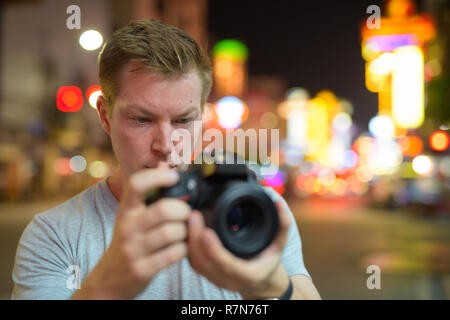 Gesicht der jungen touristische Mann fotografieren mit der Kamera in den Straßen von Chinatown bei nacht Stockfoto