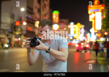 Junge touristische Mann fotografieren mit der Kamera in den Straßen von Chinatown bei nacht Stockfoto