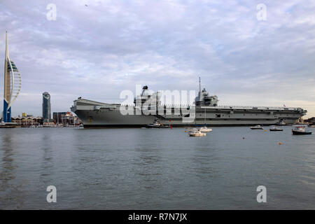 Royal Navy Flaggschiff HMS Queen Elizabeth Ankunft an Ihrem Haus Hafen von Portsmouth am 10. Dezember 2018. Die Spinnaker Tower befindet sich auf der linken Seite des Bildes Stockfoto