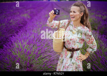 Lächelnd elegante Frau, Fotos mit der Digitalkamera im lavendelfeld in der Provence, Frankreich. Ein Blogger in der Provence nimmt Fotos für einen Touristen Stockfoto