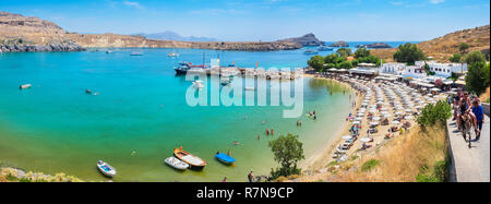 Touristen, der auf einem Esel um Lindos Bay. Lindos, Rhodos, Griechenland Stockfoto