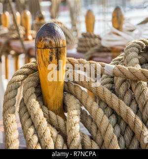 Close-up von gebündelten Seile auf dem Deck eines Segelboot. Detail der hölzernen Stollen mit nautischen günstig Seile. Stockfoto