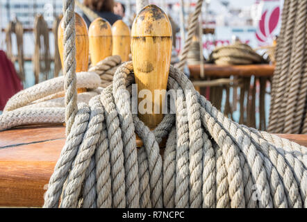 Close-up von gebündelten Seile auf dem Deck eines Segelboot. Detail der hölzernen Stollen mit nautischen günstig Seile. Stockfoto