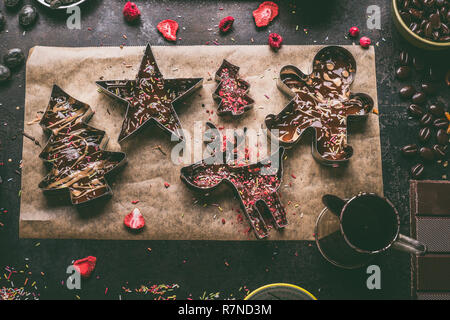 Hausgemachte Weihnachten Schokolade machen. Weihnachten Fräser mit verschiedenen Toppings und Aromen gefüllt mit geschmolzener Schokolade und Karamell auf dunklen Rost Stockfoto