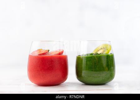 Bunte detox Roten und Grünen Smoothie in zwei Gläser auf weißem Hintergrund Stockfoto