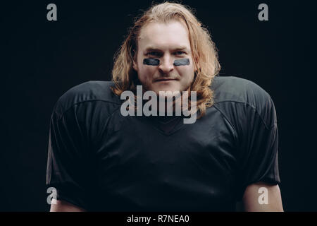 Bestimmt American football player mit bemaltem Gesicht posing und Kaugummi Stockfoto