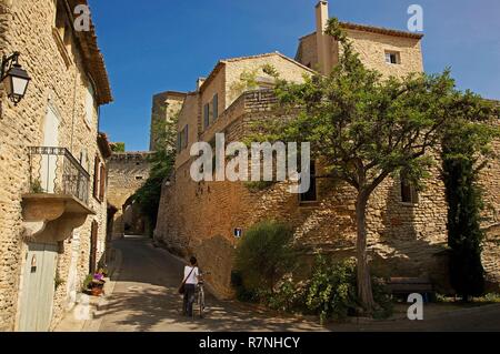 Frankreich, Vaucluse, Luberon, Goult, Frau mit seinem Fahrrad in einer Gasse in Häusern aus Stein Stockfoto