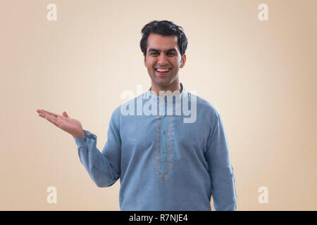 Porträt eines lächelnden jungen Mann zeigen, öffnen Sie Palm. Stockfoto