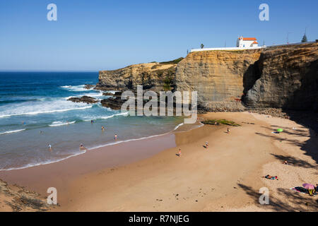 Klippe Kapelle von Igreja de Nossa Senhora do Mar mit Wellen des Atlantiks am Sandstrand in der Morgensonne brechen bei Zambujeira do Mar Stockfoto