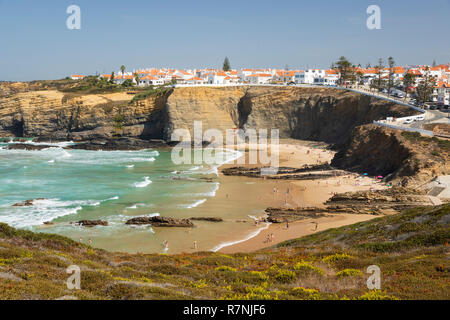 Weiß getünchte Stadt auf Klippen über Strand und brechenden Wellen des Atlantik in der Mittagssonne, Zambujeira do Mar, Alentejo, Portugal, Europa Stockfoto