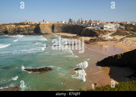 Weiß getünchte Stadt auf Klippen über Strand und brechenden Wellen des Atlantik in der Mittagssonne, Zambujeira do Mar, Alentejo, Portugal, Europa Stockfoto