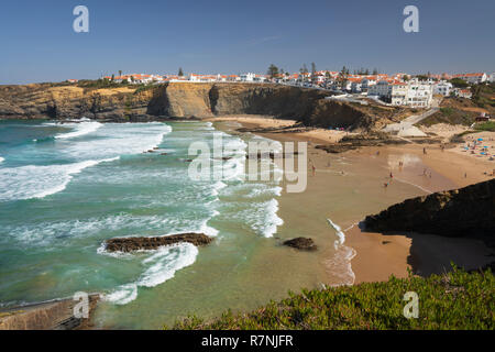 Weiß getünchte Stadt auf Klippen über Strand und brechenden Wellen des Atlantik in der Mittagssonne, Zambujeira do Mar, Alentejo, Portugal, Europa Stockfoto