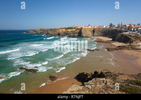 Weiß getünchte Stadt auf Klippen über Strand und brechenden Wellen des Atlantik in der Mittagssonne, Zambujeira do Mar, Alentejo, Portugal, Europa Stockfoto