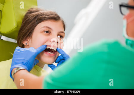 Zahnarzt untersucht die Zähne eines kleinen Mädchens. Stockfoto