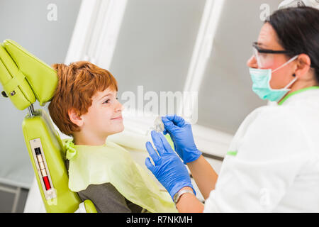 Zahnarzt ist Lehre wenig Junge über Zahnspangen. Stockfoto