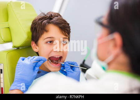 Zahnarzt untersucht die Zähne eines Jungen. Stockfoto