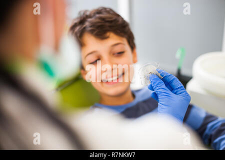 Zahnarzt ist Lehre wenig Junge über Zahnspangen. Stockfoto